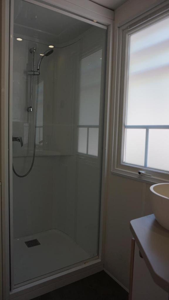 une salle de bain avec une douche avec une porte vitrée dans l'établissement Luxe chalet voor 5 personen op Camping Leï Suves - JoyCasa, à Roquebrune-sur Argens 23 autres photos