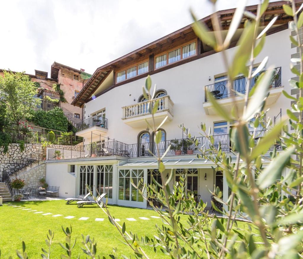 une maison avec une pelouse devant dans l'établissement Romantik Hotel Jagdhof, à Caldaro