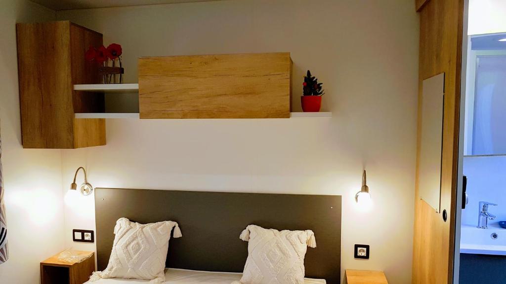 une chambre avec un lit avec deux oreillers dessus dans l'établissement Mobile home De Luxe St Cyprien, à Saint-Cyprien