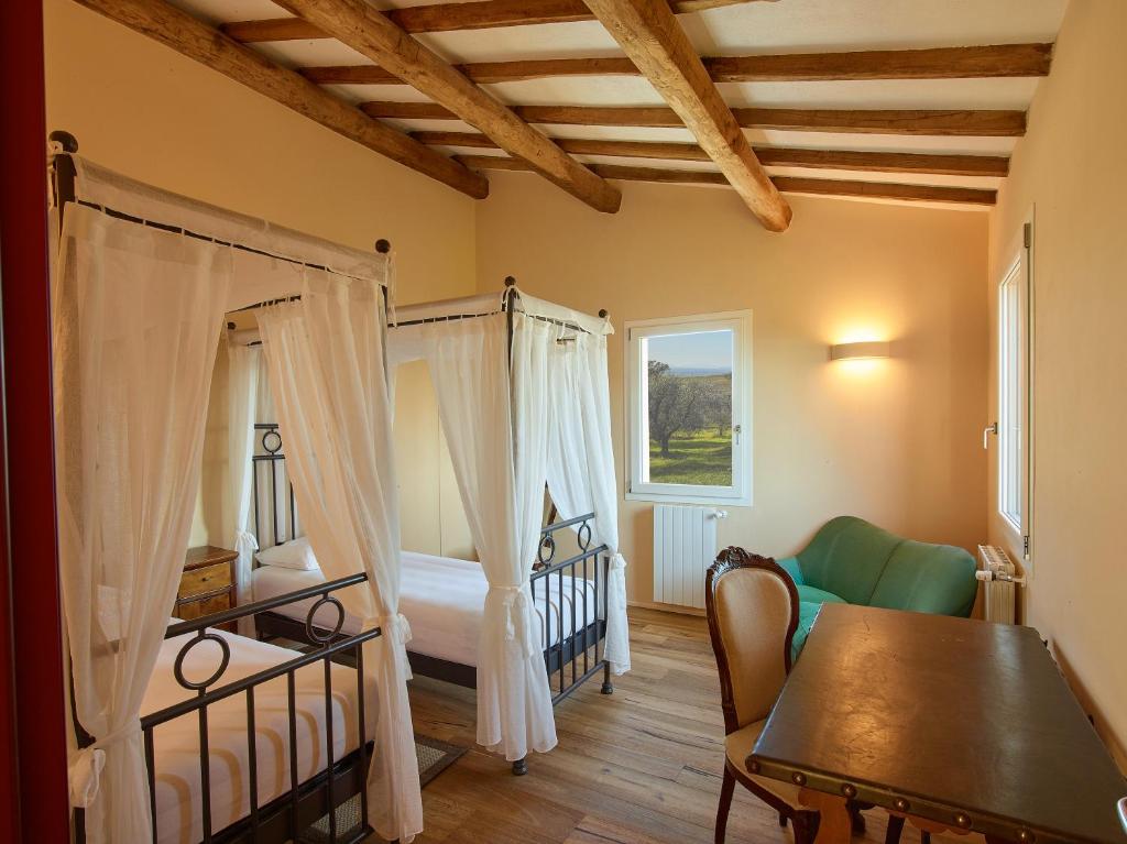 une chambre avec un lit, un canapé et une table dans l'établissement Poggio Tamantino, Villa con piscina in Maremma, à Poggio Cavallo