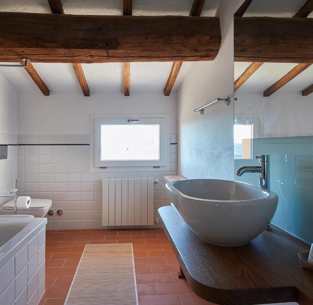 une salle de bain avec une grande baignoire et un lavabo dans l'établissement Poggio Tamantino, Villa con piscina in Maremma, à Poggio Cavallo