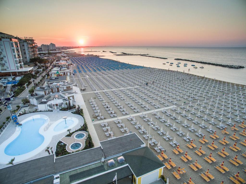 une vue aérienne d'une plage avec des parasols et l'océan dans l'établissement Mediterraneo Hotel & Suites, à Cattolica