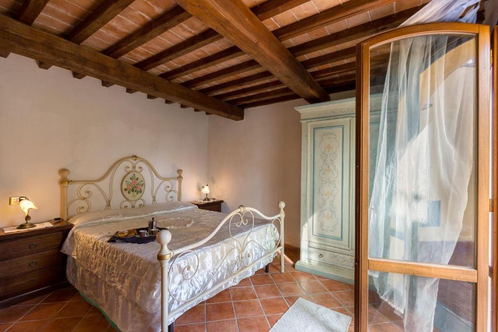 une chambre avec un lit et un plafond en bois dans l'établissement Agriturismo La Fragola, à Cignano