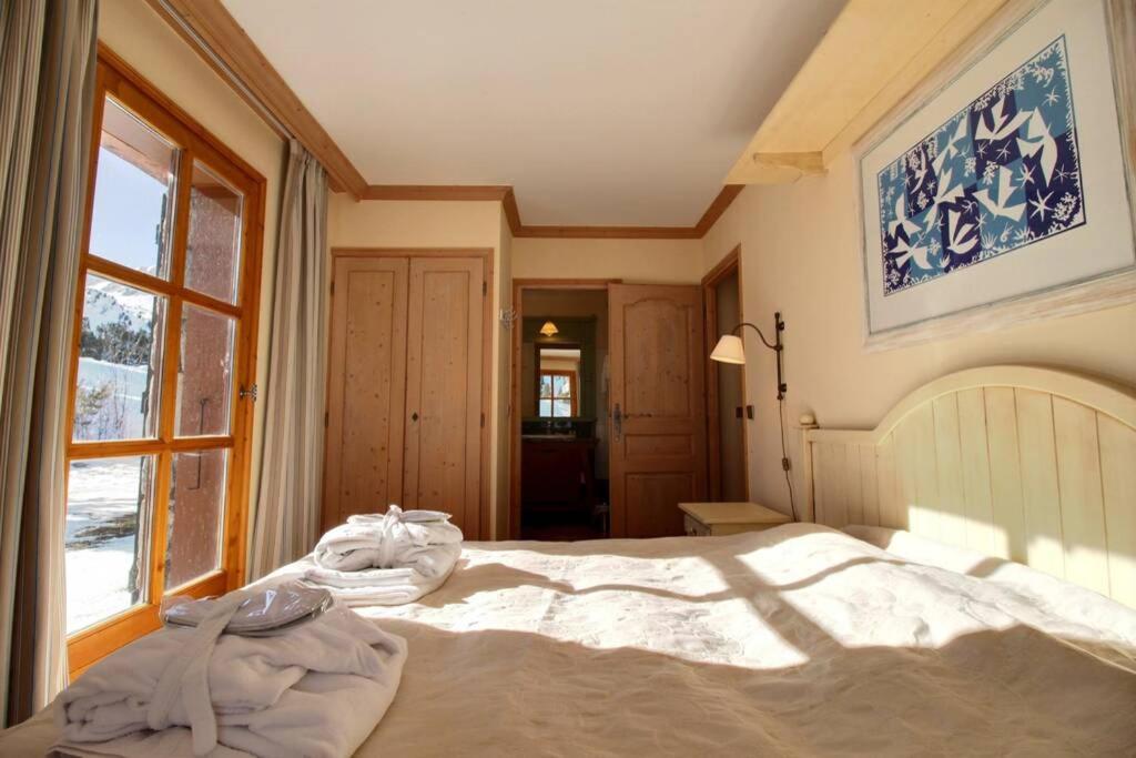 une chambre avec un grand lit et une fenêtre dans l'établissement LE PLUS BEL APPARTEMENT DES ARCS 1950 SKI/PISCINE, à Bourg-Saint-Maurice 13 autres photos
