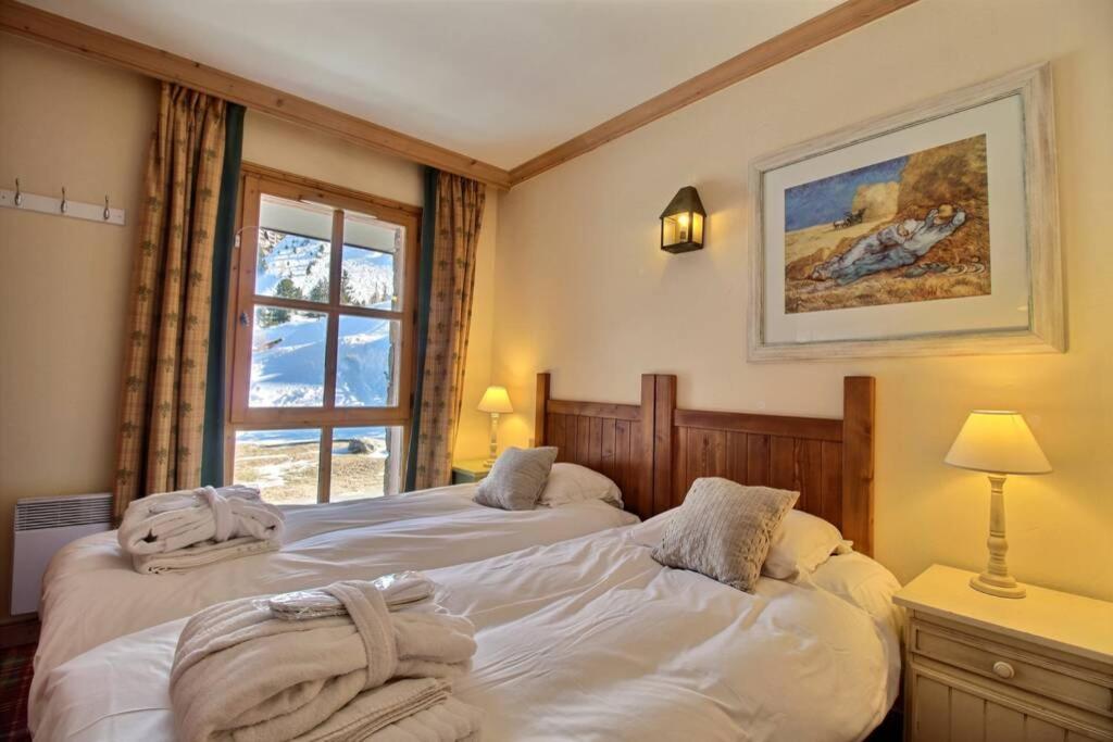 une chambre avec deux lits blancs et une fenêtre dans l'établissement LE PLUS BEL APPARTEMENT DES ARCS 1950 SKI/PISCINE, à Bourg-Saint-Maurice