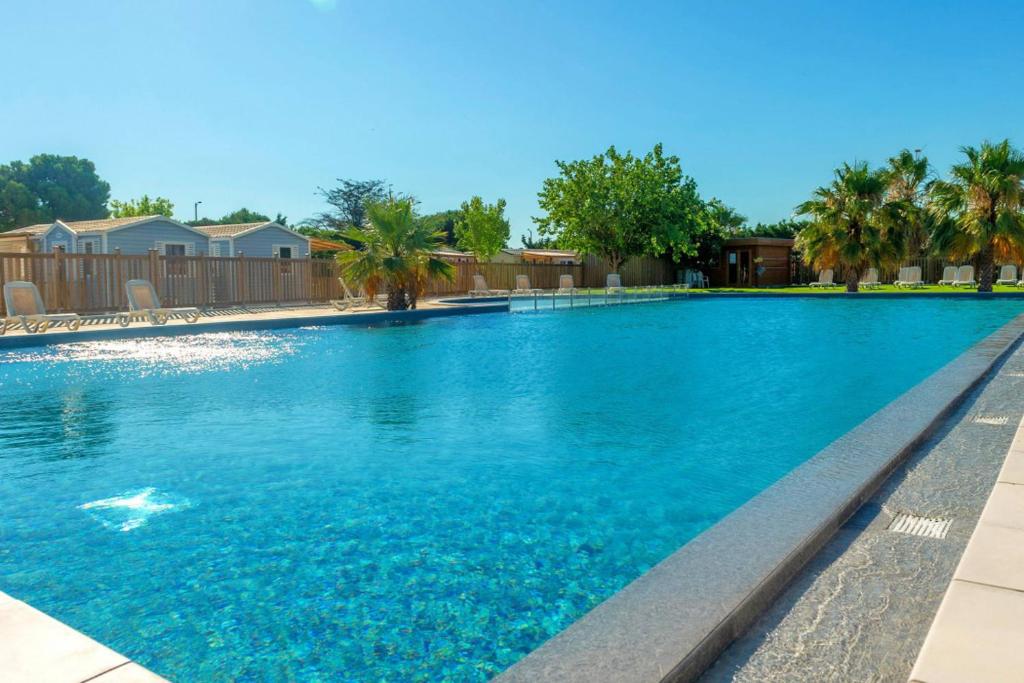 une grande piscine avec de l'eau bleue dans l'établissement Mobil home 4 personnes Port la nouvelle, à Port-la-Nouvelle