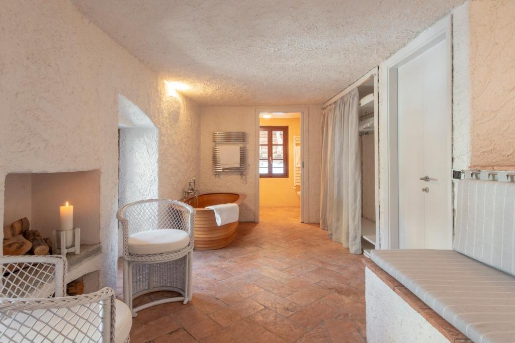 une chambre avec une salle de bain avec une baignoire et une table dans l'établissement La Filanda - The House Of Travelers, à Brienno