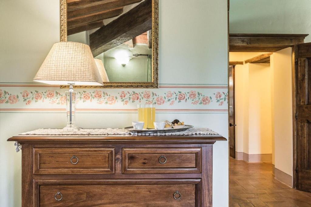 un miroir et une commode avec une lampe au-dessus dans l'établissement Torre Del Cielo, à Monterchi