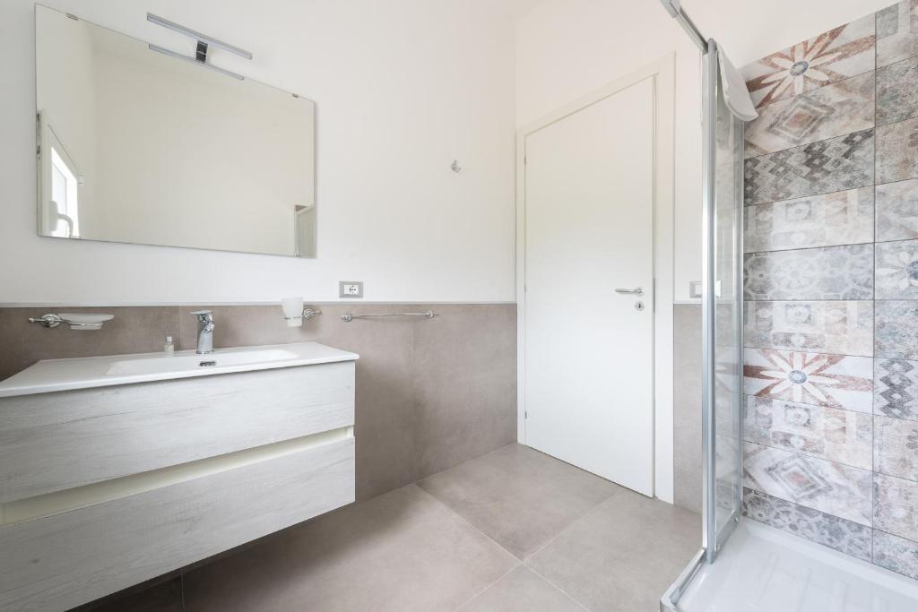 une salle de bain avec un lavabo et un miroir dans l'établissement Villa Iris - IsulaTravel, à Pozzallo 39 autres photos