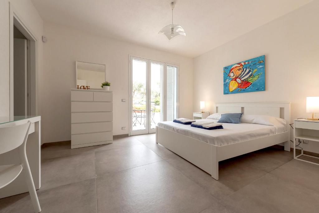 une chambre avec un lit, une table et un miroir dans l'établissement Villa Iris - IsulaTravel, à Pozzallo