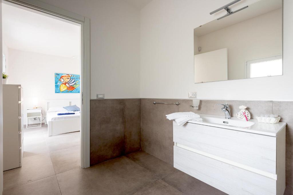 - une cuisine blanche avec un évier et un miroir dans l'établissement Villa Iris - IsulaTravel, à Pozzallo