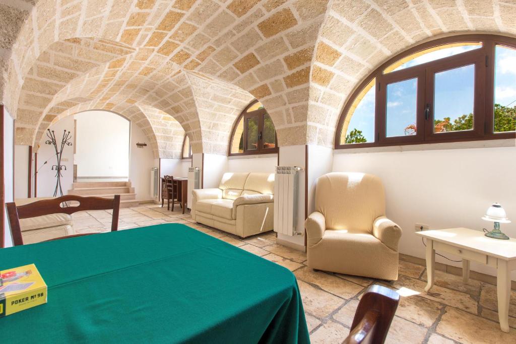 - un salon avec une table et des chaises vertes dans l'établissement Villa Martina by BarbarHouse, à Carovigno