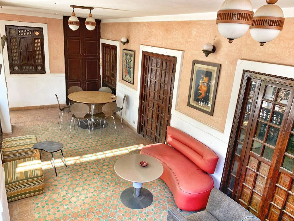 un salon avec un canapé rouge et une table dans l'établissement Riad Rockech, à Marrakech