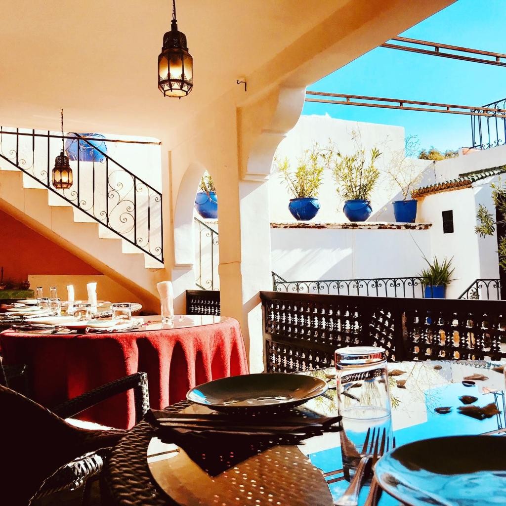 un restaurant avec des tables et des chaises et un balcon dans l'établissement Riad Rockech, à Marrakech