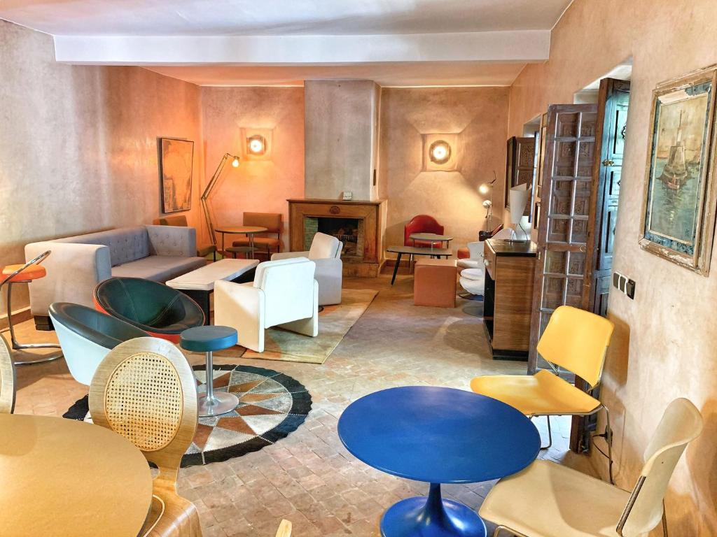 un salon avec un canapé, des tables et des chaises dans l'établissement Riad Rockech, à Marrakech