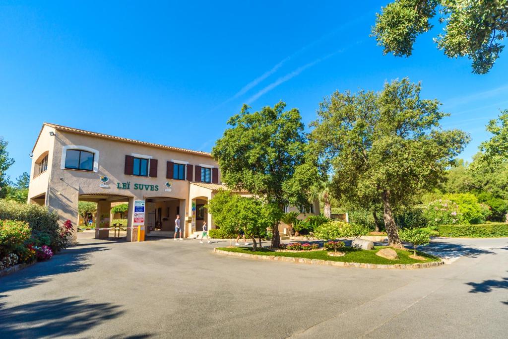 un parking vide devant un immeuble dans l'établissement Chalets met buitenkeuken op Camping Leï Suves - JoyCasa, à Roquebrune-sur Argens