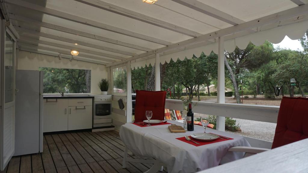 Cette chambre dispose d'une table et d'une cuisine avec vue. dans l'établissement Chalets met buitenkeuken op Camping Leï Suves - JoyCasa, à Roquebrune-sur Argens