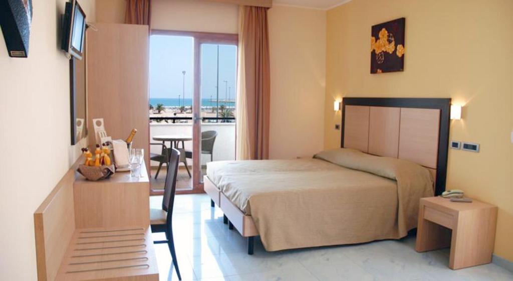 - une chambre avec un lit, une table et un balcon dans l'établissement Marc Hotel, à Vieste