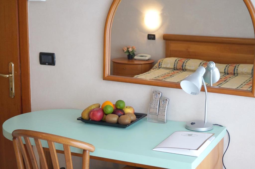 - une table avec une assiette de fruits dans une pièce dans l'établissement Hotel La Pigna, à Lignano Sabbiadoro
