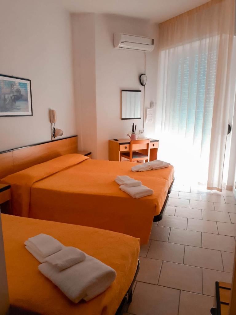 une chambre d'hôtel avec trois lits et une fenêtre dans l'établissement Hotel Admiral, à Pinarella