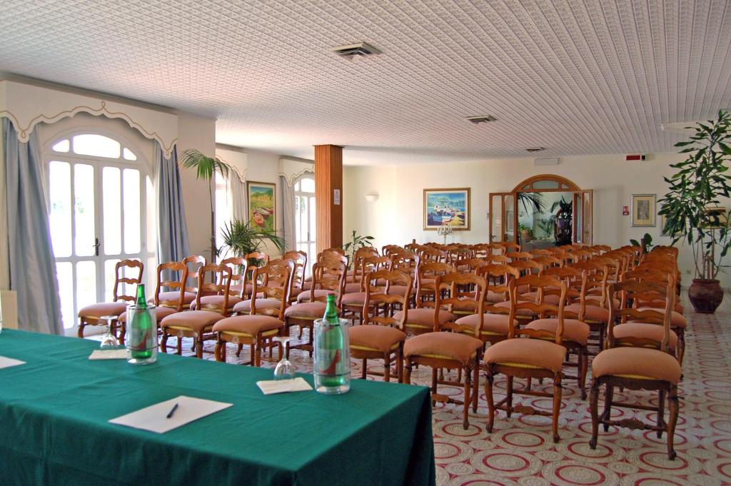 une salle de conférence avec une table et des chaises vertes dans l'établissement Hotel Lido Mediterranee, à Taormine