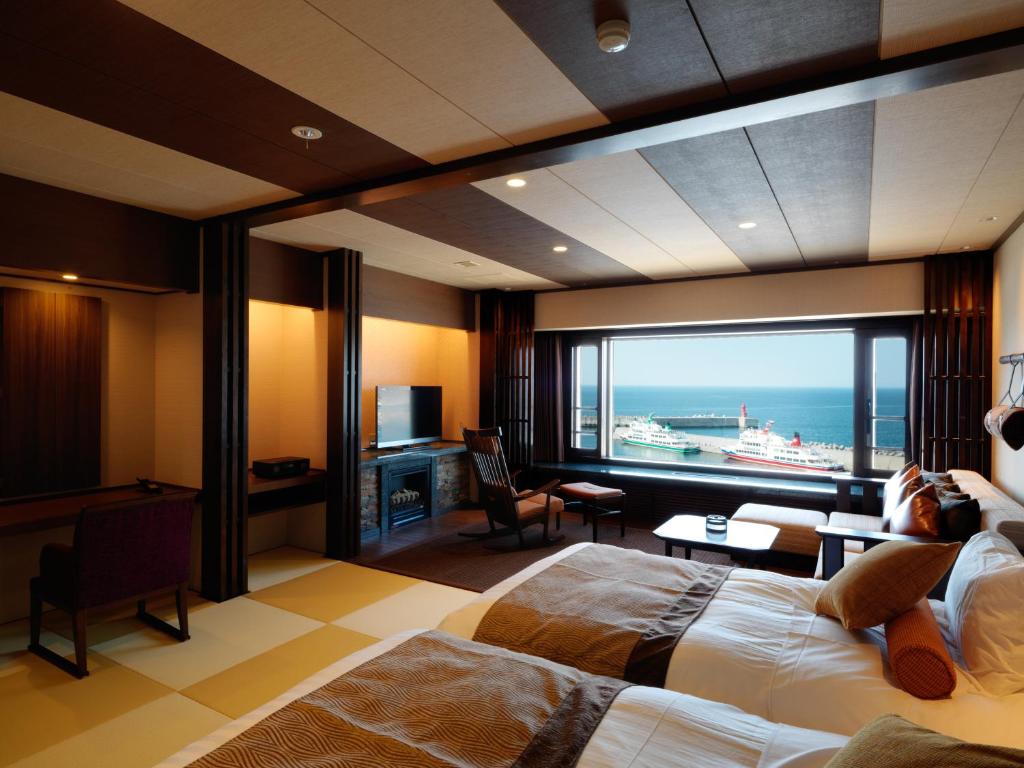 une chambre d'hôtel avec un lit et une vue sur l'océan dans l'établissement Kitakobushi Shiretoko Hotel & Resort, à Shari