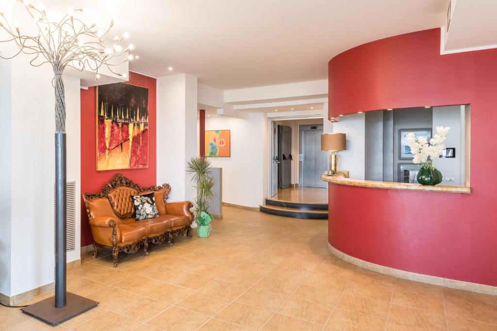 - un hall avec un canapé et un mur rouge dans l'établissement Hotel Katja, à Bibione 111 autres photos