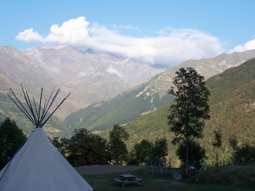 une tente blanche avec des montagnes en arrière-plan dans l'établissement Tipi nature double, à Gavarnie