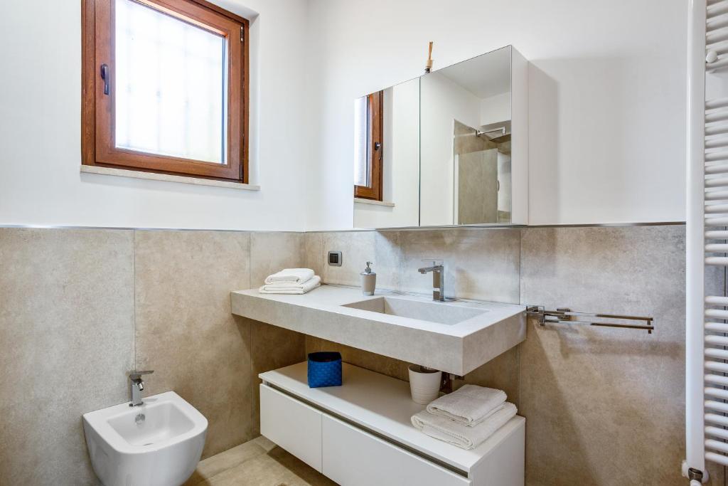 une salle de bain avec un lavabo, des toilettes et un miroir dans l'établissement Villa Santoro ai TRE Ulivi con Piscina Privata, à Caiazzo