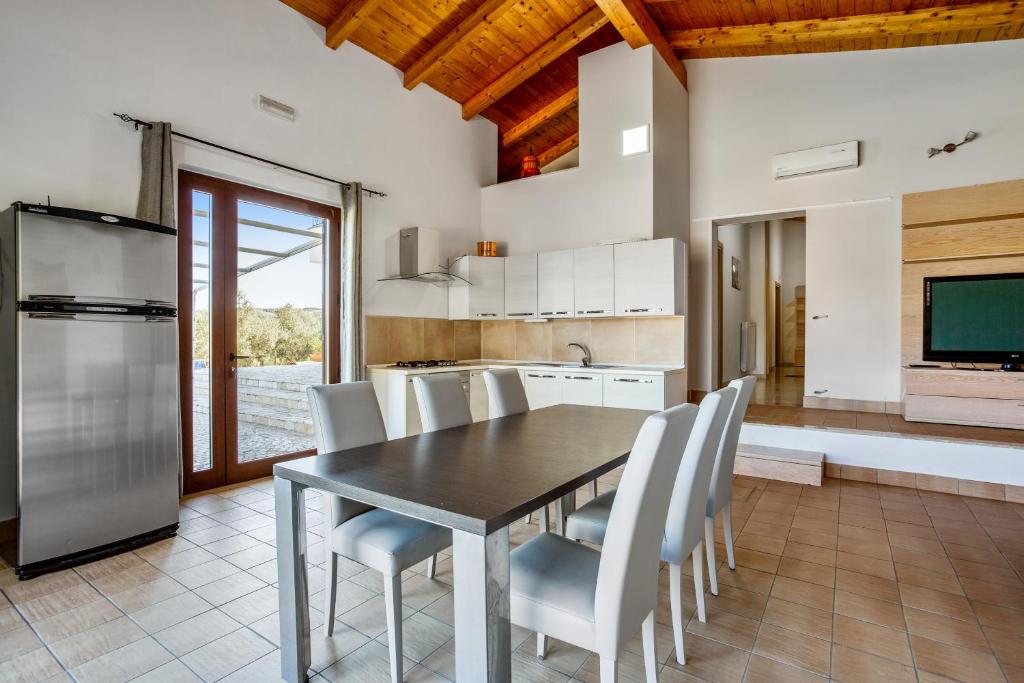 - une cuisine avec une table à manger et des chaises blanches dans l'établissement Villa Santoro ai TRE Ulivi con Piscina Privata, à Caiazzo