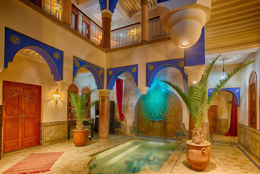 - une piscine dans un bâtiment avec une fontaine dans l'établissement Riad Kenzo, à Marrakech