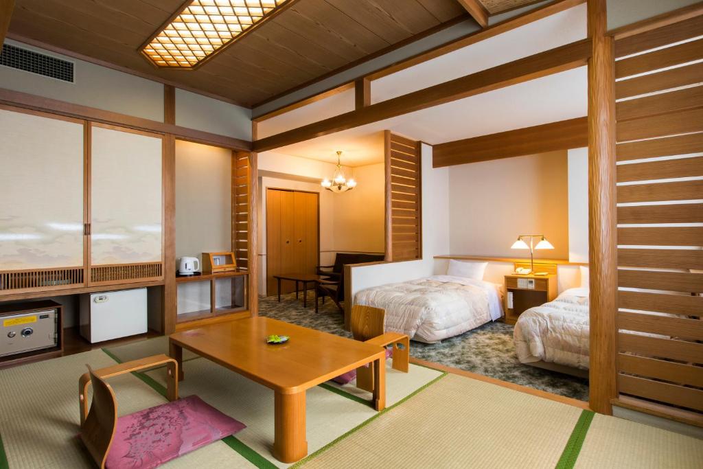 une chambre avec un lit, un bureau et une table dans l'établissement Choyo Tei, à Kamikawa