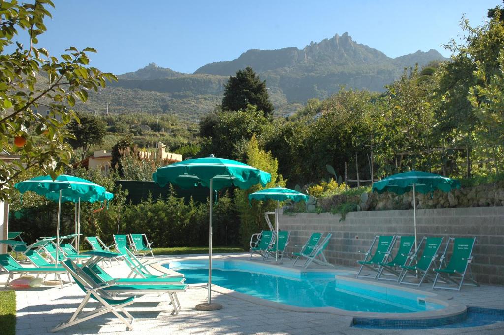 un groupe de chaises et de parasols à côté d'une piscine dans l'établissement Residence Villa Tina, à Ischia