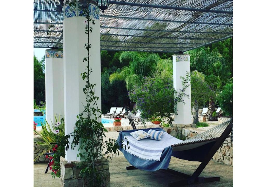 - un hamac suspendu à une pergola sur une terrasse dans l'établissement Villa panoramica con piscina, à Lido Marini