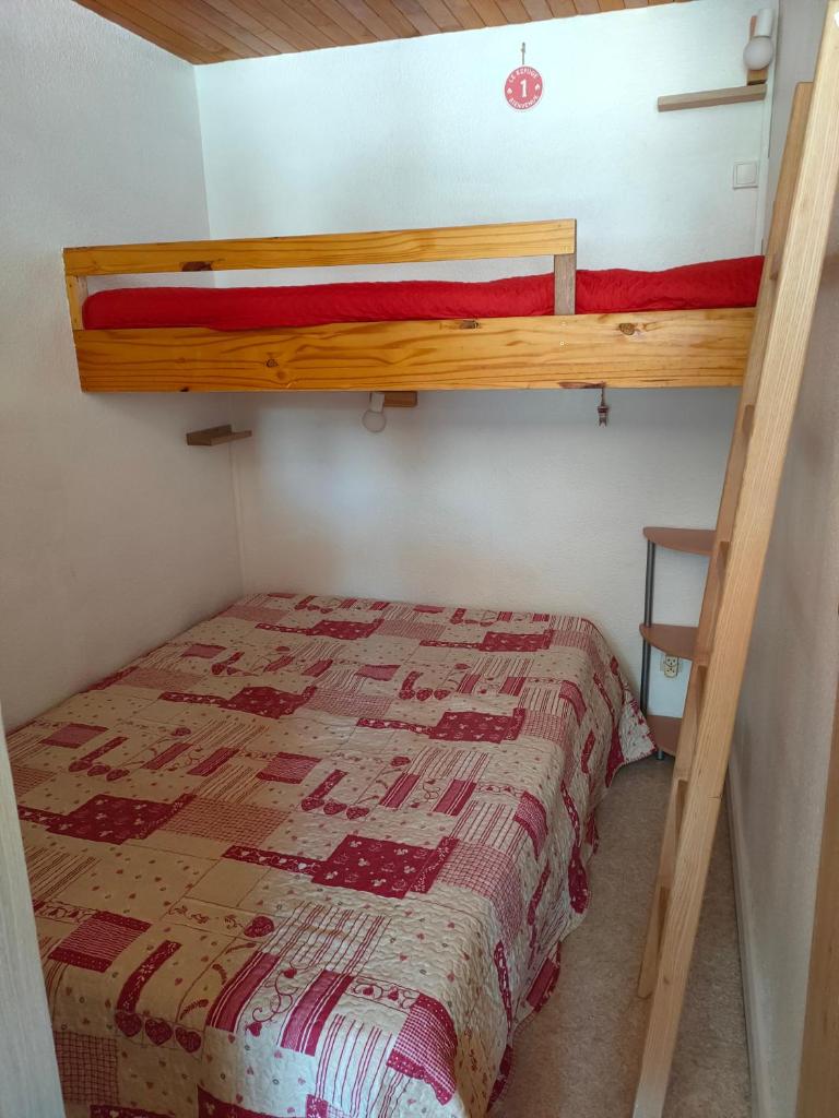 un lit superposé dans une petite pièce avec un couvre-lit dans l'établissement Corbier centre Vostok 32m2 balcon Sud vue pistes Classé Tourisme, au Corbier