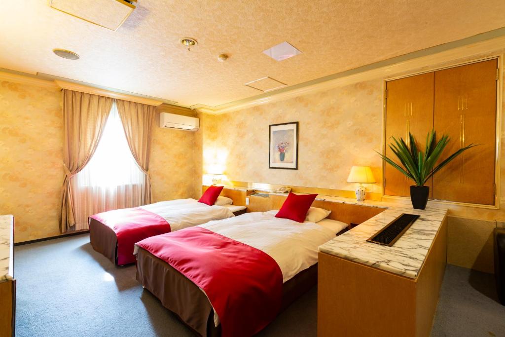 une chambre d'hôtel avec deux lits et un bureau dans l'établissement Hotel Liberty Kochi (Adult Only), à Kōchi