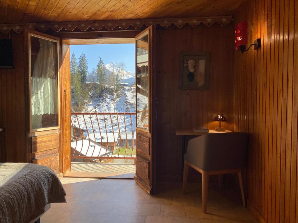 - une chambre avec un lit et une porte donnant sur un balcon dans l'établissement Chalet Génépi, à Montriond