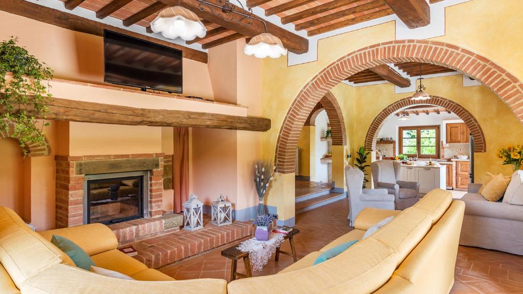 un salon avec des canapés et une cheminée dans l'établissement Il Casale Di Manuele 12, Emma Villas, à Montepulciano