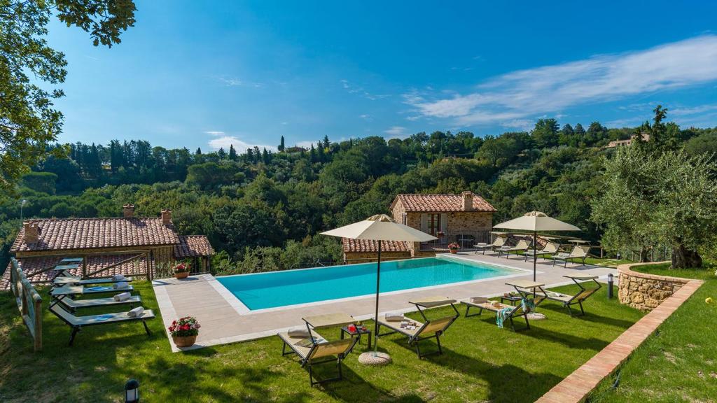 - une piscine dans une cour avec des chaises et des parasols dans l'établissement Il Casale Di Manuele 12, Emma Villas, à Montepulciano