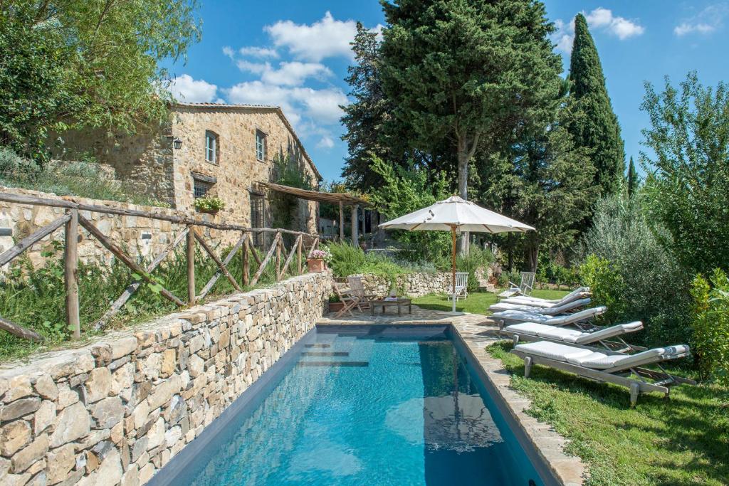 - une piscine extérieure avec des chaises longues et un parasol dans l'établissement Villa Delle Upupe 8, Emma Villas, à Castellina in Chianti