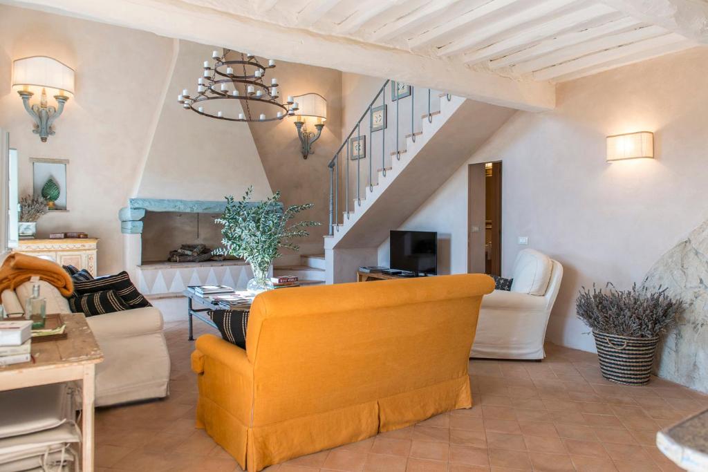 - un salon avec une chaise orange et un escalier dans l'établissement Villa Delle Upupe 8, Emma Villas, à Castellina in Chianti