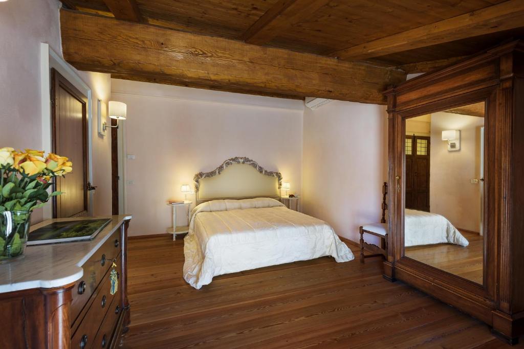 une chambre avec un lit, une commode et un miroir dans l'établissement Villa La Poiana 10 Emma Villas, à Radda in Chianti