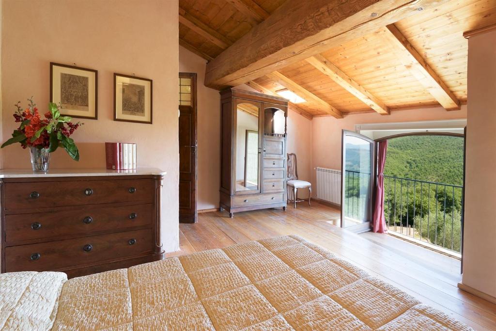 une chambre avec un lit avec une commode et un balcon dans l'établissement Villa La Poiana 10 Emma Villas, à Radda in Chianti 35 autres photos