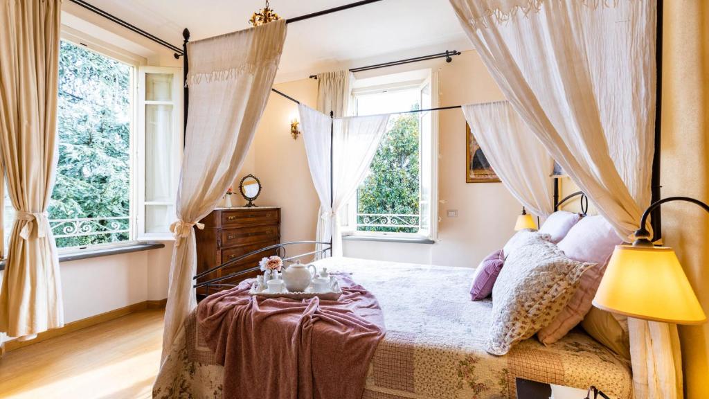 - une chambre avec un lit à baldaquin et des fenêtres dans l'établissement VILLA LUIGINA 8, Emma Villas, à Capannori 67 autres photos