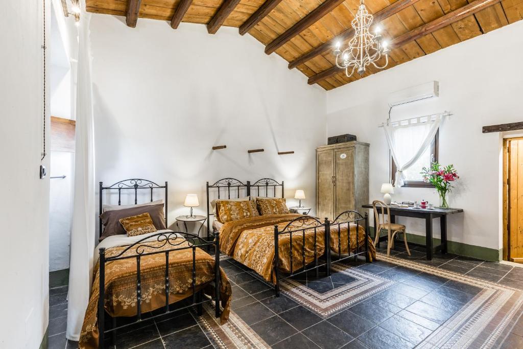 - une chambre avec 2 lits et une table dans l'établissement Authentic Sicilian Charm, pool, sea view, wi-fi & parking, à Avola