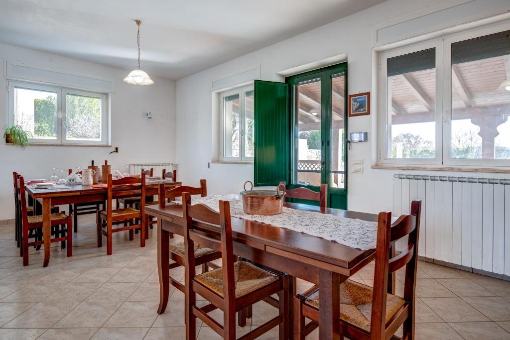 une salle à manger avec tables, chaises et fenêtres dans l'établissement Trulli Margherita, à Martina Franca