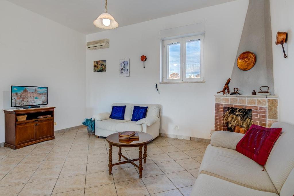 un salon avec deux canapés et une cheminée dans l'établissement Trulli Margherita, à Martina Franca