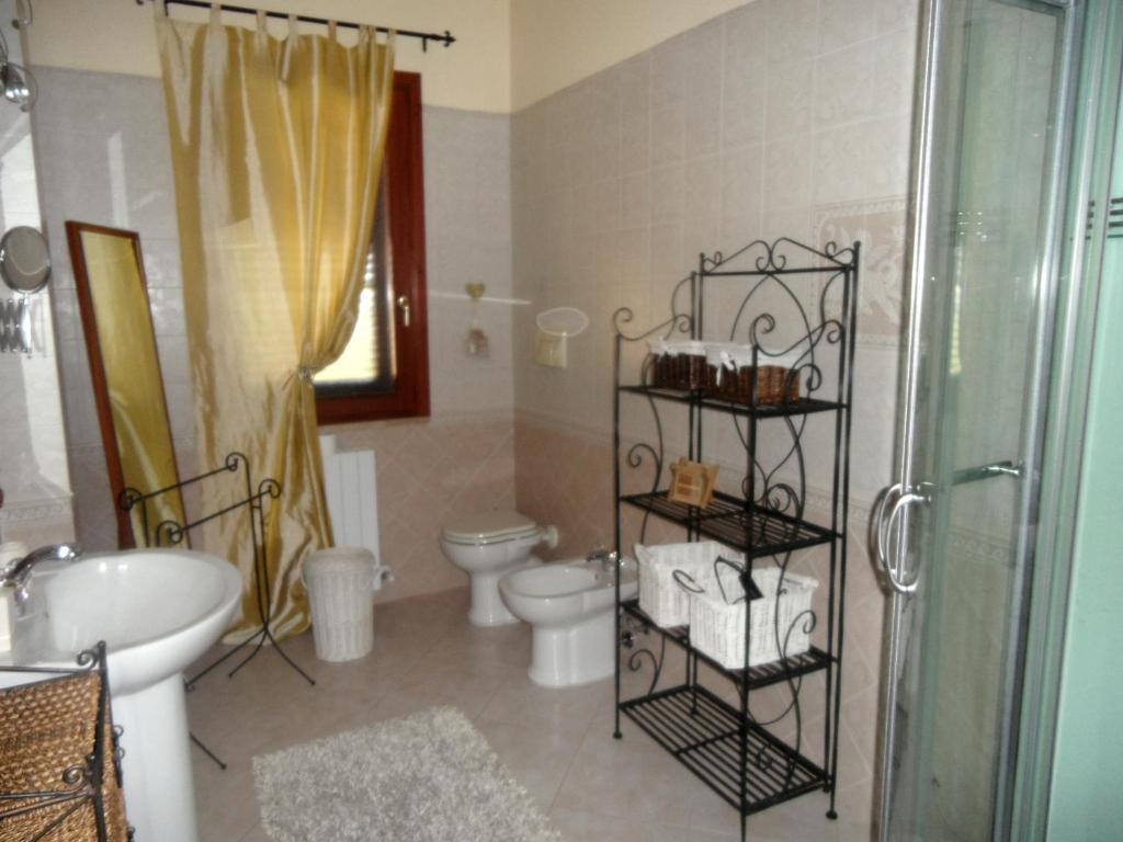 une salle de bain avec toilettes, lavabo et douche dans l'établissement Villa Graziosa, à Quartu SantʼElena