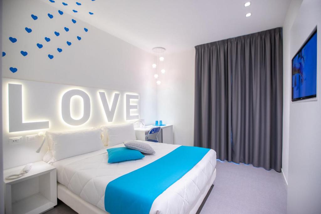 - une chambre avec un lit avec le mot amour sur le mur dans l'établissement Love Boat Hotel - The Original, à Riccione