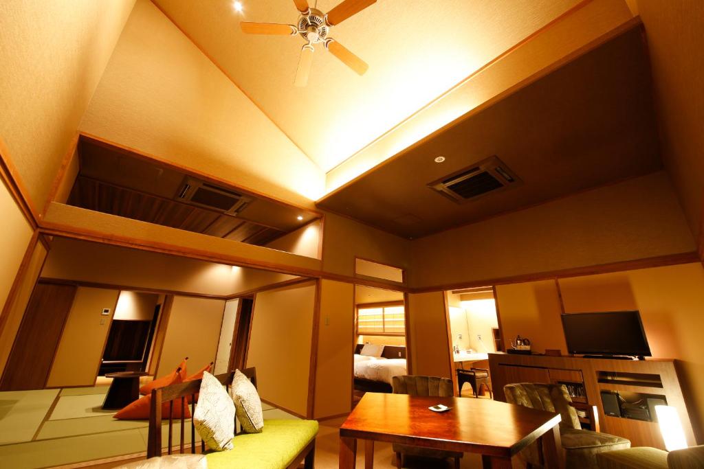 - un salon avec un ventilateur de plafond et une table dans l'établissement Awaji Hamarikyu, à Minamiawaji